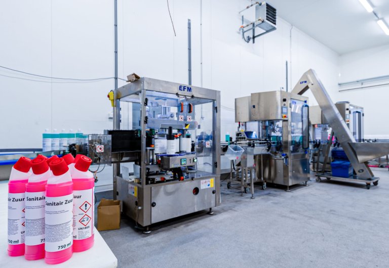 Diverse flessen op de voorgrond met op de achtergrond een productielijn