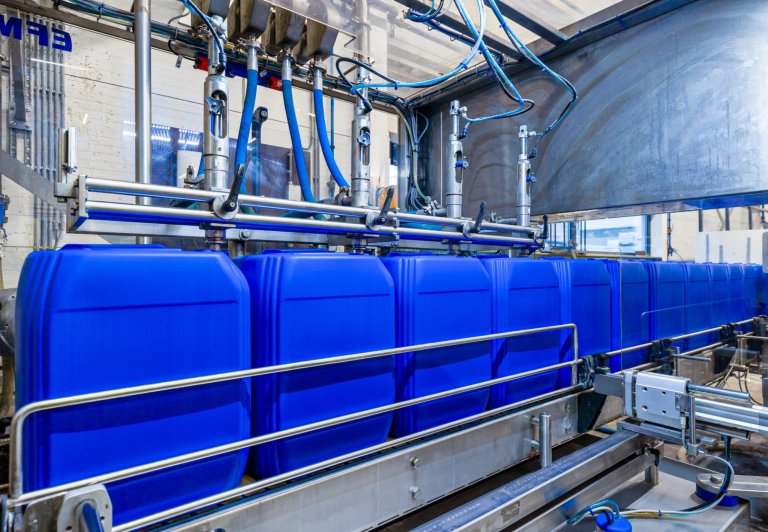 Een foto van een productielijn waar vaatjes worden gevuld